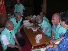 世話人のみなさんがキュウリに護符を詰めます。